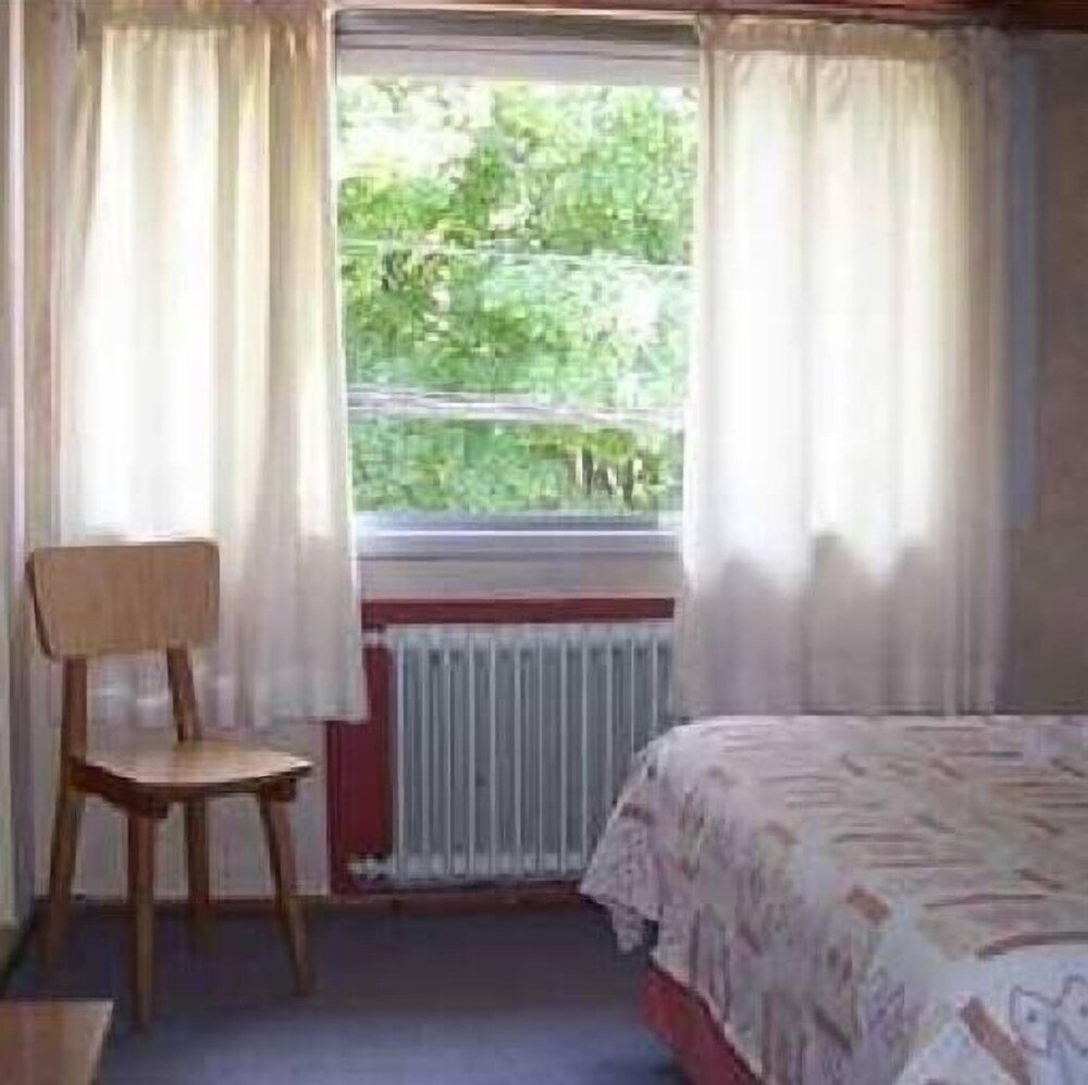 Quarto da pousada com cama e decoração simples